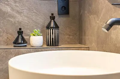 a bathroom sink with a black and white vase on a counter at Elégant et moderne T4 à 100M de La Croisette in Cannes