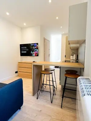 a kitchen with a table and stools in a room at Suite Palmiers d'Or Cannes in Cannes