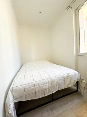 a bed in a white room with a window at Suite Palmiers d'Or Cannes in Cannes