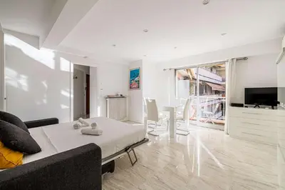 a living room with a couch and a table at LE LOUIS BLANC avec balcon en plein centre-ville in Cannes