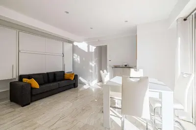 a living room with a couch and a table at LE LOUIS BLANC avec balcon en plein centre-ville in Cannes