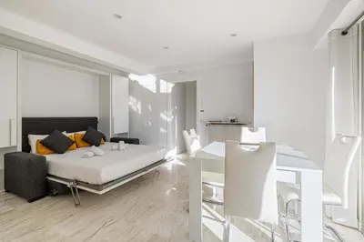 a bedroom with a bed and a table and chairs at LE LOUIS BLANC avec balcon en plein centre-ville in Cannes