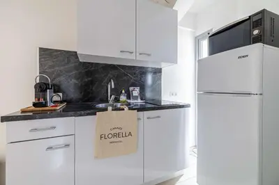 a kitchen with white cabinets and a paper bag on the counter at LE LOUIS BLANC avec balcon en plein centre-ville in Cannes