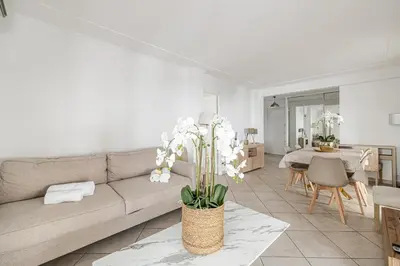 a living room with a couch and a table at 78 LERINS - Bel appartement 2 chambres sur la Croisette in Cannes