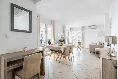 a living room with a table and a dining room at 78 LERINS - Bel appartement 2 chambres sur la Croisette in Cannes