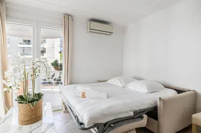 a bedroom with a bed in a room with a window at 78 LERINS - Bel appartement 2 chambres sur la Croisette in Cannes