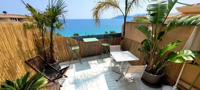a patio with a table and chairs and the ocean at Theo'z apartments in Cannes