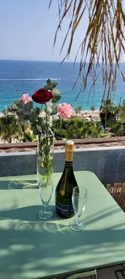 a table with a bottle of wine and two glasses at Theo'z apartments in Cannes