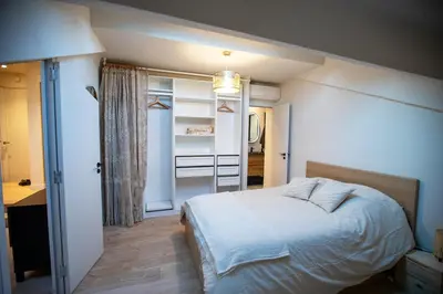 a bedroom with a white bed and a bathroom at Stylish Central Cannes Apartment in Cannes