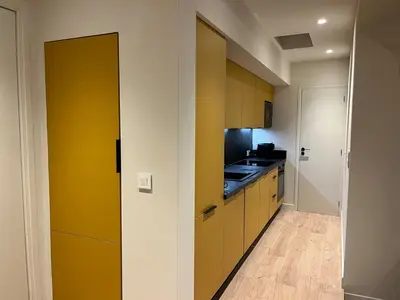 a kitchen with yellow cabinets and a counter top at Stylish Central Cannes Apartment in Cannes