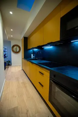 a kitchen with yellow cabinets and a stove top oven at Stylish Central Cannes Apartment in Cannes