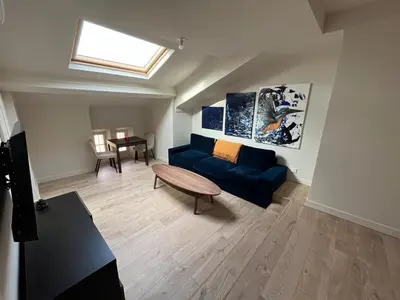 a living room with a blue couch and a table at Stylish Central Cannes Apartment in Cannes