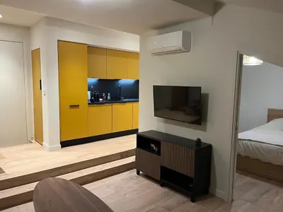 a bedroom with yellow cabinets and a bed and a television at Stylish Central Cannes Apartment in Cannes