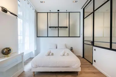 a bedroom with a white bed with two pillows at Le 121 - LOFT design Rue d'Antibes in Cannes