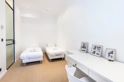 a white room with two beds and a table at Le 121 - LOFT design Rue d'Antibes in Cannes