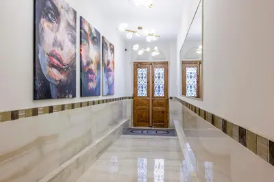 a hallway with paintings on the walls and a wooden door at Le 121 - LOFT design Rue d'Antibes in Cannes