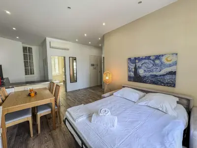 a bedroom with a bed and a table and a painting at RED DOOR Forville Market View in Cannes