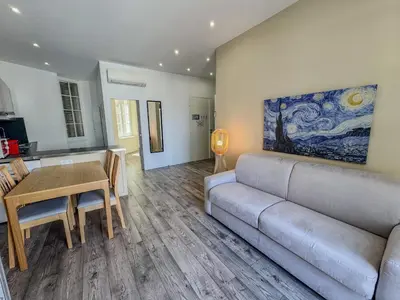 a living room with a couch and a table at RED DOOR Forville Market View in Cannes