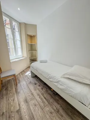 a bedroom with a bed and a chair and a window at RED DOOR Forville Market View in Cannes