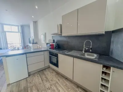 a kitchen with white cabinets and a sink at RED DOOR Forville Market View in Cannes