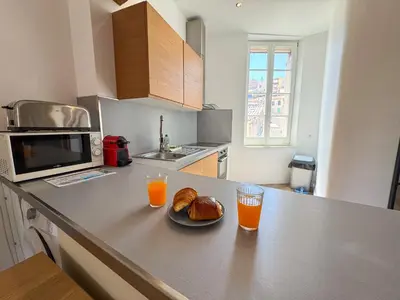 a kitchen with a plate of bread and two glasses of orange juice at WOOD Forville Suquet View in Cannes