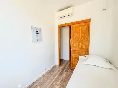 a bedroom with a bed and a wooden door at WOOD Forville Suquet View in Cannes
