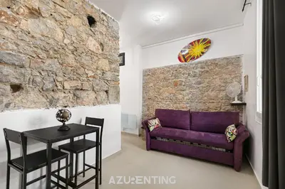 a living room with a purple couch and a table at Azurenting - Bastide Alba - Studio - Terrasse in Cannes