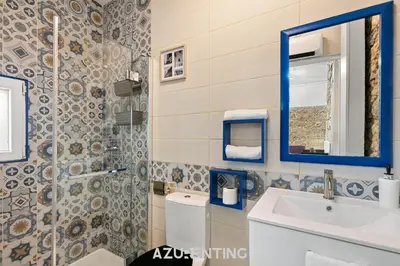 a living room with a stone wall and a couch at Azurenting - Bastide Alba - Studio - Terrasse in Cannes