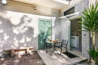 a green door with a red chair in front of a house at Azurenting - Bastide Alba - Studio - Terrasse in Cannes