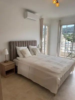 a bedroom with a large bed with a large window at Magnifique T2 avec grande terrasse in Le Cannet