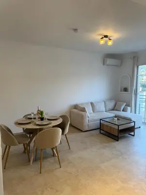 a living room with a table and a couch at Magnifique T2 avec grande terrasse in Le Cannet