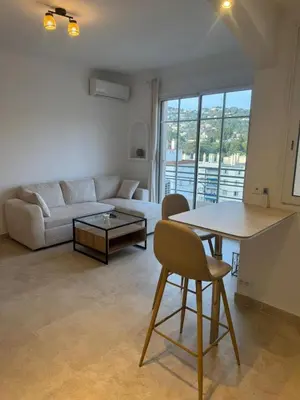 a living room with a couch and a table at Magnifique T2 avec grande terrasse in Le Cannet