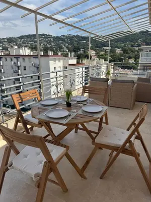 a wooden table and chairs on a balcony at Magnifique T2 avec grande terrasse in Le Cannet