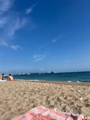 a beach with people sitting on the sand and the ocean at La Palme studio in Cannes