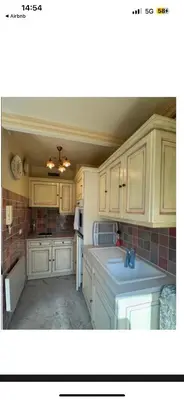 a kitchen with white cabinets and a counter top at La Palme studio in Cannes
