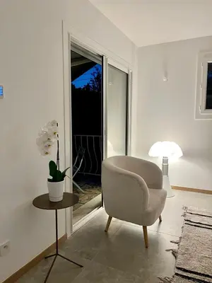 a living room with a chair and a table and a window at 4 bedroom house Le Cannet in Le Cannet