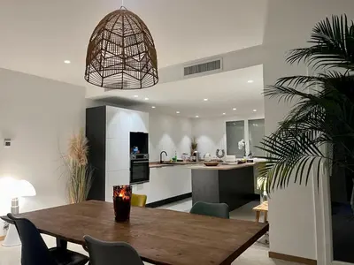 a dining room and living room with a table and a kitchen at 4 bedroom house Le Cannet in Le Cannet