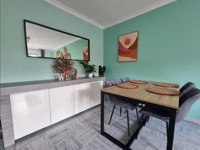 a dining room with a table and a mirror at Appartement entier cosy au calme in Le Cannet