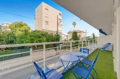 a balcony with blue chairs and tables on a balcony at 2 chambres - Grand balcon - à 1 min de la plage in Cannes