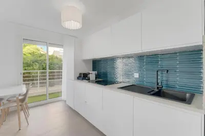 a kitchen with a sink and a table and a window at 2 chambres - Grand balcon - à 1 min de la plage in Cannes