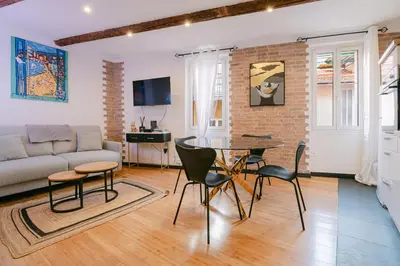 a living room with a couch and a table and chairs at La Casa du Suquet, zone piétonne in Cannes