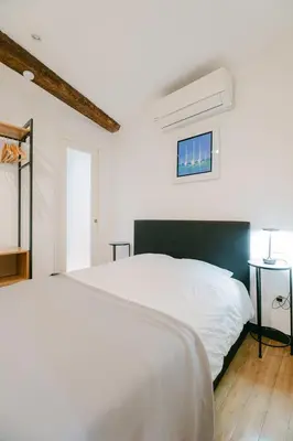 a white bedroom with a white bed with a green headboard at La Casa du Suquet, zone piétonne in Cannes