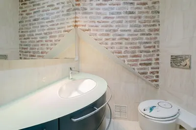 a bathroom with a sink and a brick wall at La Casa du Suquet, zone piétonne in Cannes