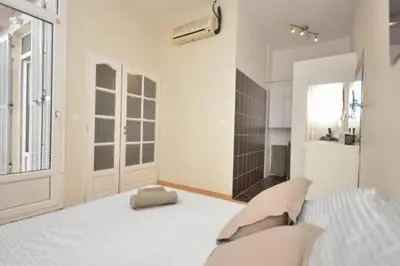 a white bedroom with a bed and a bathroom at La Terrasse 4 Cannes French Riviera in Cannes