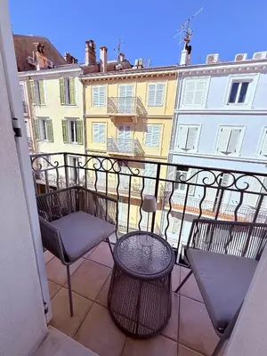 a balcony with chairs and a table and a building at Le Pinson Mignon Cannes Carre d Or in Cannes