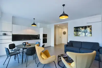 a living room with a blue couch and a table and chairs at YELLOW DUBOY D'ANGERS 2 Bedrooms in Cannes