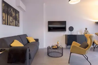 a living room with a couch and a tv at YELLOW DUBOY D'ANGERS 2 Bedrooms in Cannes
