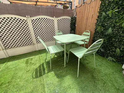 a table and chairs on the grass in a backyard at T2 avec terrasse 4p, Cannes centre in Cannes
