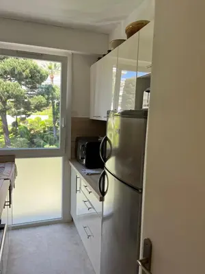 a kitchen with a stainless steel refrigerator and a window at Charming Flat close to beach in Cannes