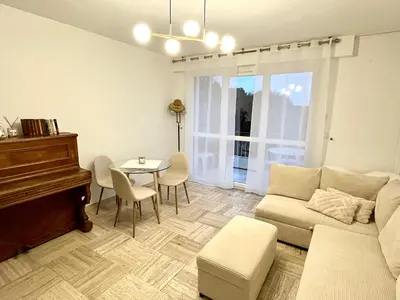 a living room with a couch and a table and a piano at Charming Flat close to beach in Cannes